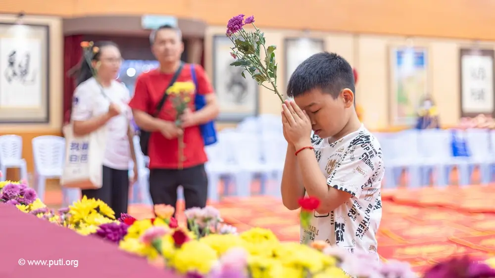 浴佛節裡持花向佛祖祈禱的小男孩