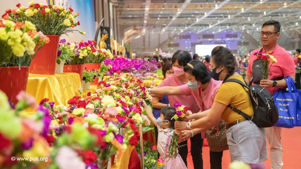 参加浴佛节的一家人正在佛前献花